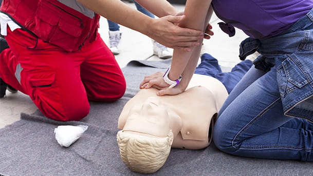 Un homme pratique en formation le massage cardiaque sur un mannequin
